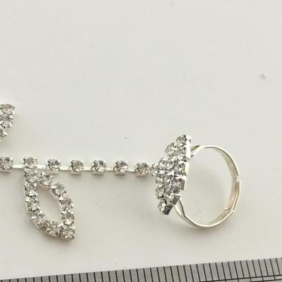 Silver tone bracelet with attached ring adjustable
