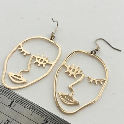Gold tone face earrings