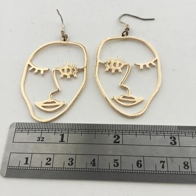 Gold tone face earrings