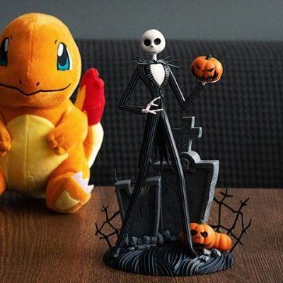 Pop culture collectibles arrangement including a Charmander plush, Jack Skellington figure on a graveyard base, Spider-Man Funko Pop, and...