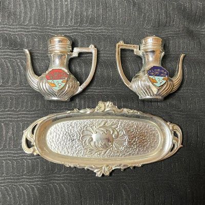 Vintage metal teapot-shaped salt and pepper shakers featuring colorful enamel Florida crests, complete with a matching ornate silver-tone...