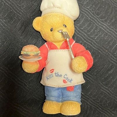 Vintage Cherished Teddies resin figurine featuring a bear chef wearing a 'Kiss the Cook' apron and holding a hamburger.