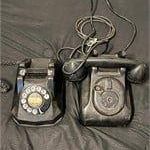 Two vintage black rotary telephones, including a Western Electric Model 302, showing signs of age and wear.