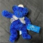 Russ Berrie plush teddy bear in royal blue with a sheer white bow and original tags attached.
