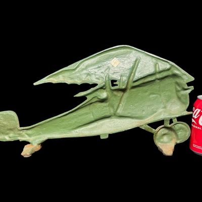 Sale Photo Thumbnail #18: This piece is constructed of cast iron, and was made in Taiwan. The original sticker is on the reverse. This was typically used as a door stop or wall hanging. It is modeled after a WW1 bi-plane. There is age related wear, including minor surface rust. Me