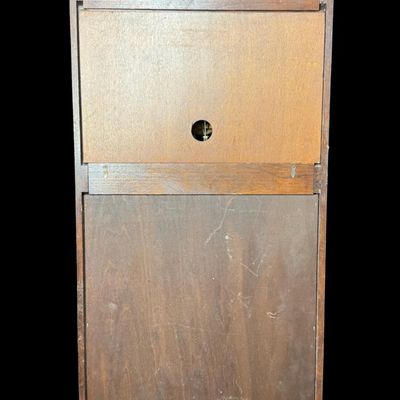 Sale Photo Thumbnail #50: This piece features a fluted wooden case and lower viewing glass showcasing the brass pendulum bob. It was made in West Germany. The key is included. The clock is working at the time of catalog. Measurement: 26.5”H x 12.5”W x 5.5”D. [MI]