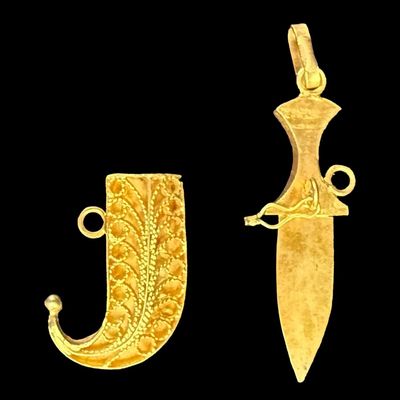 Sale Photo Thumbnail #60: This two-piece pendant is crafted from 18K yellow gold. The scabbard features intricate filigree. The clasp needs to be adjusted, and the safety chain is missing. The overall length is 1 3/8” long, and the weight is 2.79 grams. The gold content was conf