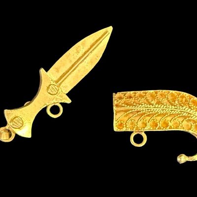 Sale Photo Thumbnail #61: This two-piece pendant is crafted from 18K yellow gold. The scabbard features intricate filigree. The clasp needs to be adjusted, and the safety chain is missing. The overall length is 1 3/8” long, and the weight is 2.79 grams. The gold content was conf
