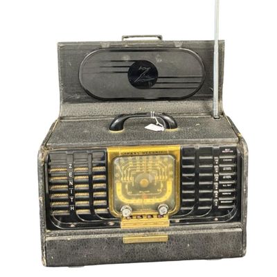 Sale Photo Thumbnail #115: This is a Zenith Model 8G005-YTZ1 portable tube radio. It was manufactured in 1948, and features six bands for AM and shortwave listening. It is built into a portable “suitcase” style cabinet covered in black leatherette, with a front drop-down “chi