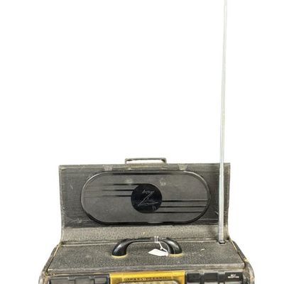 Sale Photo Thumbnail #116: This is a Zenith Model 8G005-YTZ1 portable tube radio. It was manufactured in 1948, and features six bands for AM and shortwave listening. It is built into a portable “suitcase” style cabinet covered in black leatherette, with a front drop-down “chi