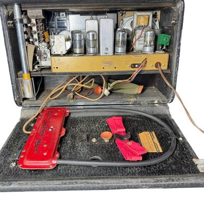 Sale Photo Thumbnail #117: This is a Zenith Model 8G005-YTZ1 portable tube radio. It was manufactured in 1948, and features six bands for AM and shortwave listening. It is built into a portable “suitcase” style cabinet covered in black leatherette, with a front drop-down “chi