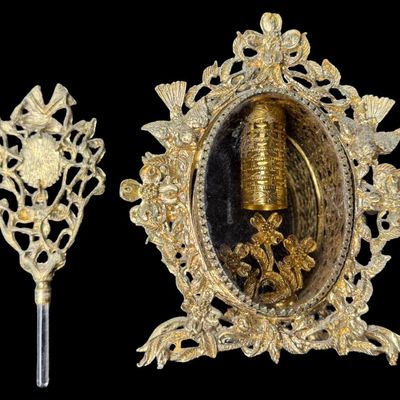 Sale Photo Thumbnail #200: Most likely from the mid-20th century, these structures feature heavily detailed gilt brass filigree with motifs of flowers, scrolling vines, and birds, surrounding the center. There are encased perfume bottles in each piece. Total of two pieces. One is m