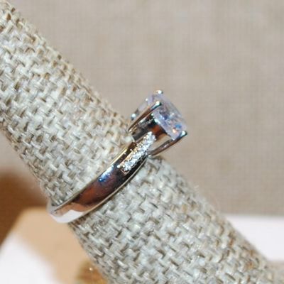 Size 6 Single Round Clear Stone Ring with Faint Line Accents on a Silver Tone Band (3.4g)
