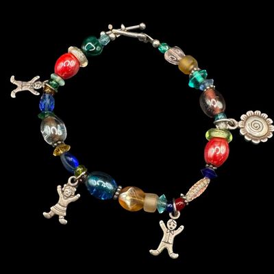 Sale Photo Thumbnail #355: This bracelet features multi-colored beads, sterling silver charms, and sterling silver accents and clasp. Some components are marked “925.” The silver content of other components was confirmed with testing. The clasp needs repair. The overall weight 