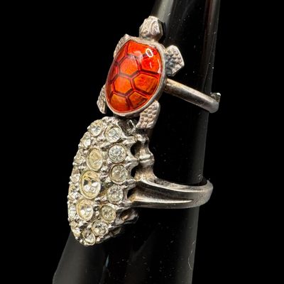 Sale Photo Thumbnail #357: Includes a vintage Meka of Denmark adjustable enameled turtle ring, and a cluster ring with clear stones (size 8.75). Both rings are marked “Sterling.” The total weight is 7.67 grams. [PM]