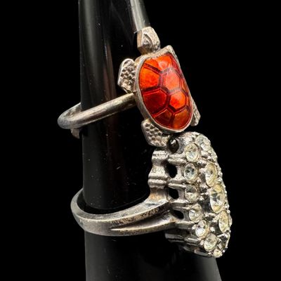 Sale Photo Thumbnail #358: Includes a vintage Meka of Denmark adjustable enameled turtle ring, and a cluster ring with clear stones (size 8.75). Both rings are marked “Sterling.” The total weight is 7.67 grams. [PM]