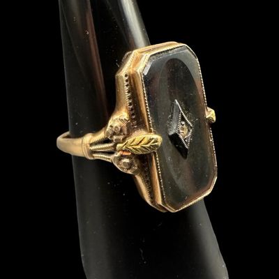 Sale Photo Thumbnail #365: This Victorian-era ladies’ ring features a rectangular piece of black onyx set in yellow gold, centered with a miner cut accent diamond mounted in a white gold frame. The mourning ring symbolized remembrance, grief, or elegant sentimentality. The ring s