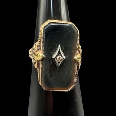 Sale Photo Thumbnail #363: This Victorian-era ladies’ ring features a rectangular piece of black onyx set in yellow gold, centered with a miner cut accent diamond mounted in a white gold frame. The mourning ring symbolized remembrance, grief, or elegant sentimentality. The ring s
