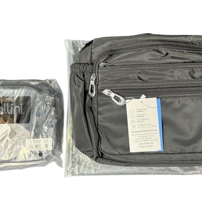 Sale Photo Thumbnail #409: Includes a black waterproof crossbody/shoulder bag, and a Baggalini triple zip bag. Total of two unopened bags. The crossbody bag has an anti-theft RFID chip. Measurement of largest: 14” x 9”. [GG]