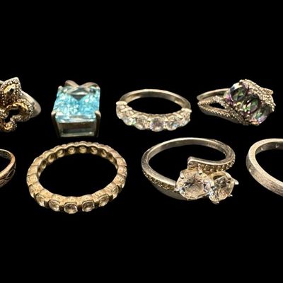 Sale Photo Thumbnail #427: Includes rings, a toe ring, and a blue topaz pendant. Stones include mystic topaz, CZ, turquoise, and more. Total of eight pieces. The total weight is 26.62 grams. [GG]