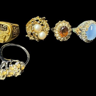 Sale Photo Thumbnail #477: Includes gold tone, silver tone, stones, faux pearls, and more. There are both men’s and ladies’ rings in various styles. Total of ten rings. [PM]