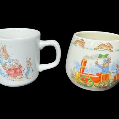 Sale Photo Thumbnail #573: Includes a vintage Wedgwood Peter Rabbit mug from Beatrix Potter’s famous illustrations, and a Royal Doulton Bunnykins mug in the Albion shape. There is minimal crazing to the Wedgwood piece. There are no obvious chips or cracks in either piece. Measure