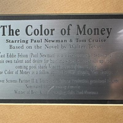 Sale Photo Thumbnail #634: This piece features an enlarged photo of Tom Cruise and Paul Newman, along with a pool stick, chalk, and cue balls. There is a marquis plaque commemorating this movie centered on the base. Measurement: 30” x 30”. [VB]