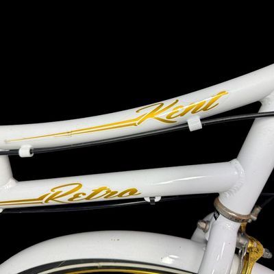 Sale Photo Thumbnail #648: This is constructed of a lightweight aluminum step-through frame, with distinct gold script accents. It features front and rear hand-operated side pull caliper brakes. It is gently used, though there may be stains or pitting in places. [AG]