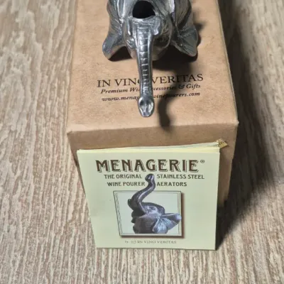 Sale Photo Thumbnail #135: The Elephant Head Pourer/Aerator/Stopper is a unique and fun addition to any bar collection. Made of metal with a silver color, this head-shaped pourer features an elephant design that adds a charming touch to your kitchen or home decor. Perfect for aerat