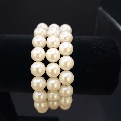 Sale Photo Thumbnail #144: Assorted costume jewelry lot featuring white bead and faux pearl stretch bracelets, a patriotic red, white and blue beaded bracelet, gold-tone fashion bracelets with faux pearls and rhinestones, a black-and-white bangle, and a coordinating white beaded ne