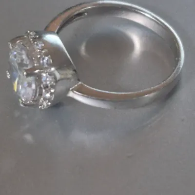 Sale Photo Thumbnail #175: Sterling Engagement Ring w/ CZ white zircon [ size 8.25 ]
Marked CFJ , located in Saginaw , Tx 1983.
Ring has a center CZ White Zircon in a halo setting
excel. condition,  no scuffs to naked eye
