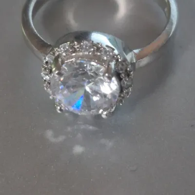 Sale Photo Thumbnail #174: Sterling Engagement Ring w/ CZ white zircon [ size 8.25 ]
Marked CFJ , located in Saginaw , Tx 1983.
Ring has a center CZ White Zircon in a halo setting
excel. condition,  no scuffs to naked eye