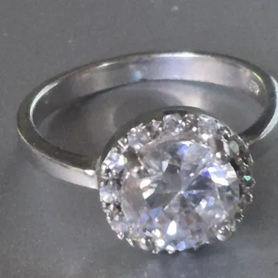 Sale Photo Thumbnail #173: Sterling Engagement Ring w/ CZ white zircon [ size 8.25 ]
Marked CFJ , located in Saginaw , Tx 1983.
Ring has a center CZ White Zircon in a halo setting
excel. condition,  no scuffs to naked eye
