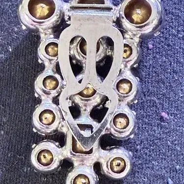 Sale Photo Thumbnail #200: A beautiful vintage rhinestone fur clip in the unmistakable Eisenberg style, featuring a bold, dimensional arrangement of faceted clear stones in a classic silver-tone setting. The design showcases a mix of round and rectangular cuts, creating depth, bril