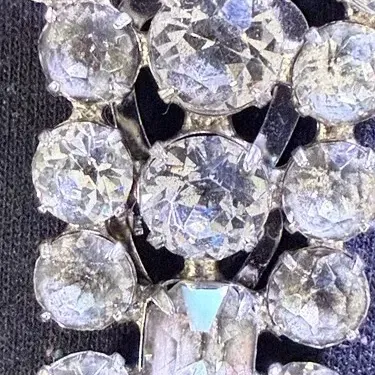 Sale Photo Thumbnail #199: A beautiful vintage rhinestone fur clip in the unmistakable Eisenberg style, featuring a bold, dimensional arrangement of faceted clear stones in a classic silver-tone setting. The design showcases a mix of round and rectangular cuts, creating depth, bril