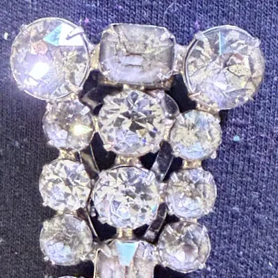Sale Photo Thumbnail #201: A beautiful vintage rhinestone fur clip in the unmistakable Eisenberg style, featuring a bold, dimensional arrangement of faceted clear stones in a classic silver-tone setting. The design showcases a mix of round and rectangular cuts, creating depth, bril