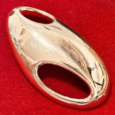 Sale Photo Thumbnail #122: This is a rare Trifari brooch from the 1970s designed by Kunio Matsumoto. It features a modernist abstract design in gold tone, measuring 2.5 inches in length. Signed by Trifari, this vintage piece is oval in shape and does not contain any stones. It is a