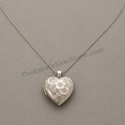Sale Photo Thumbnail #20: Vintage-style sterling silver heart locket with detailed floral and scroll engraving, suspended from a fine 20-inch silver chain. Locket opens to two small photo compartments and closes securely. Marked 925; estimated combined gross weight 11.6 grams. Lig