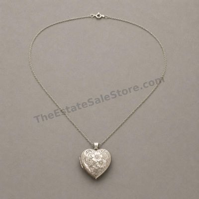 Sale Photo Thumbnail #19: Vintage-style sterling silver heart locket with detailed floral and scroll engraving, suspended from a fine 20-inch silver chain. Locket opens to two small photo compartments and closes securely. Marked 925; estimated combined gross weight 11.6 grams. Lig