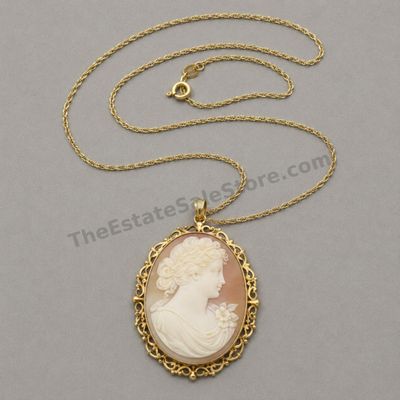 Sale Photo Thumbnail #25: Large oval shell cameo-style portrait of a classical woman in profile, mounted in an ornate yellow-gold openwork frame that functions as both pendant and brooch. Includes a 20-inch fine gold chain. Frame and chain marked 14K; estimated combined gross weig