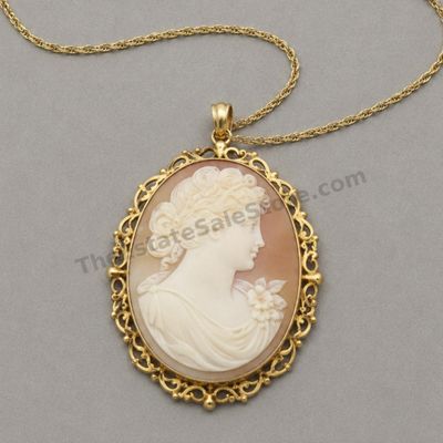 Sale Photo Thumbnail #26: Large oval shell cameo-style portrait of a classical woman in profile, mounted in an ornate yellow-gold openwork frame that functions as both pendant and brooch. Includes a 20-inch fine gold chain. Frame and chain marked 14K; estimated combined gross weig