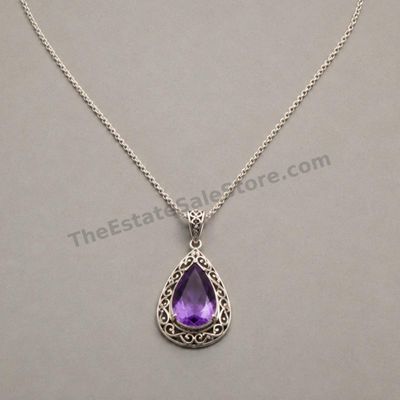 Sale Photo Thumbnail #28: Decorative sterling silver teardrop pendant set with a faceted purple amethyst-style stone in an open scrollwork frame. Suspended from an adjustable 18- to 20-inch cable chain. Marked 925; estimated combined gross weight 9.7 grams. Clean condition with li
