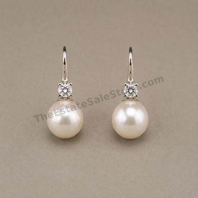Sale Photo Thumbnail #33: Matched pair of white-gold drop earrings, each featuring a round diamond-style accent above a luminous cultured pearl-style drop. Lever-back ear wires provide secure closure. Marked 14K; approximate drop length 1 inch and estimated combined gross weight 4