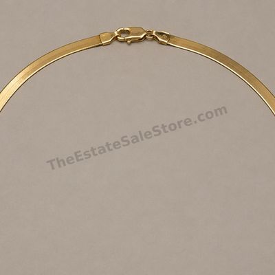 Sale Photo Thumbnail #46: Flat yellow-gold herringbone necklace with a smooth reflective finish and secure lobster clasp. Approximate length 18 inches and width 5 mm; marked 14K; estimated gross weight 12.3 grams. Several light surface scratches and one gentle wave from storage ar