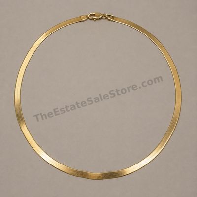 Sale Photo Thumbnail #45: Flat yellow-gold herringbone necklace with a smooth reflective finish and secure lobster clasp. Approximate length 18 inches and width 5 mm; marked 14K; estimated gross weight 12.3 grams. Several light surface scratches and one gentle wave from storage ar