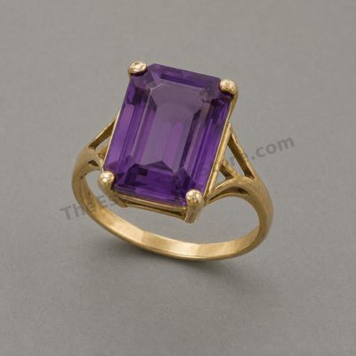 Sale Photo Thumbnail #60: Large yellow-gold cocktail ring centered by an emerald-cut purple amethyst-style stone in a high four-prong basket. Decorative pierced shoulders add vintage character. Marked 14K; approximate ring size 7 and estimated gross weight 7.5 grams. Light band we