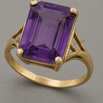 Sale Photo Thumbnail #59: Large yellow-gold cocktail ring centered by an emerald-cut purple amethyst-style stone in a high four-prong basket. Decorative pierced shoulders add vintage character. Marked 14K; approximate ring size 7 and estimated gross weight 7.5 grams. Light band we