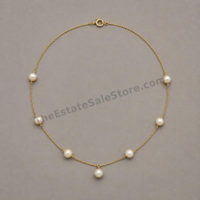 Sale Photo Thumbnail #61: Elegant yellow-gold station necklace featuring seven evenly spaced cultured pearl-style beads on a fine 20-inch chain. Marked 750; estimated gross weight 9.2 grams. Pearls display creamy luster with small natural-looking surface blemishes; clasp has minor