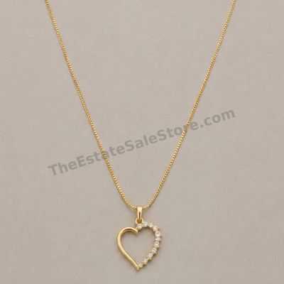 Sale Photo Thumbnail #64: Polished yellow-gold open-heart pendant accented along one side with graduated round diamond-style stones, suspended from an 18-inch box chain. Marked 14K; estimated combined gross weight 5.1 grams. The pendant reverse shows fine scratches from contact wi
