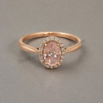 Sale Photo Thumbnail #73: Rose-gold ring centered by an oval peach-pink morganite-style stone surrounded by a halo of small diamond-style accents. Marked 14K; approximate ring size 7.25 and estimated gross weight 4.6 grams. Light surface wear with small scratches at the bottom of 